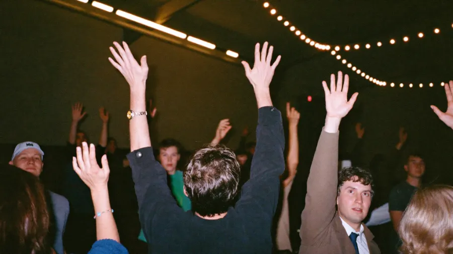 People raising their hands at a community gathering